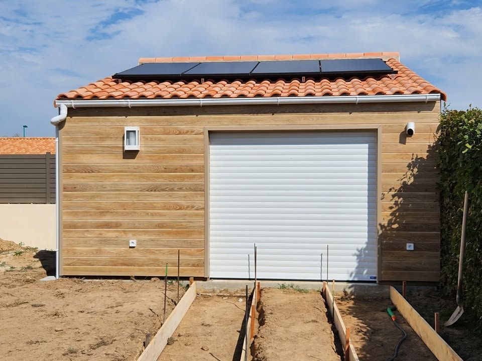 Garage bardé de bois, porte enroulable motorisée et panneaux solaires